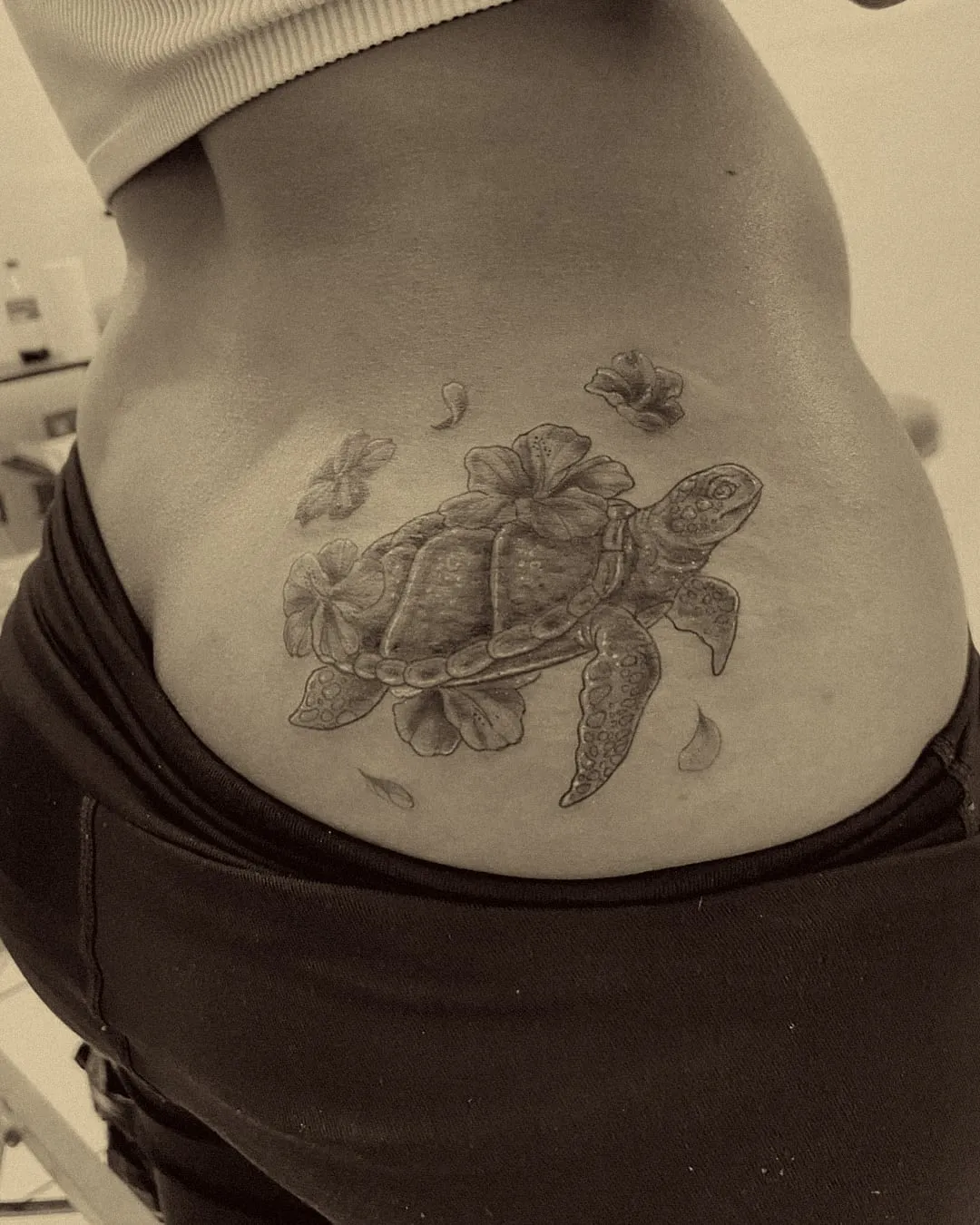 Tortuga marina con flores de hibisco en negro, gris y lila, cover-up en la cadera