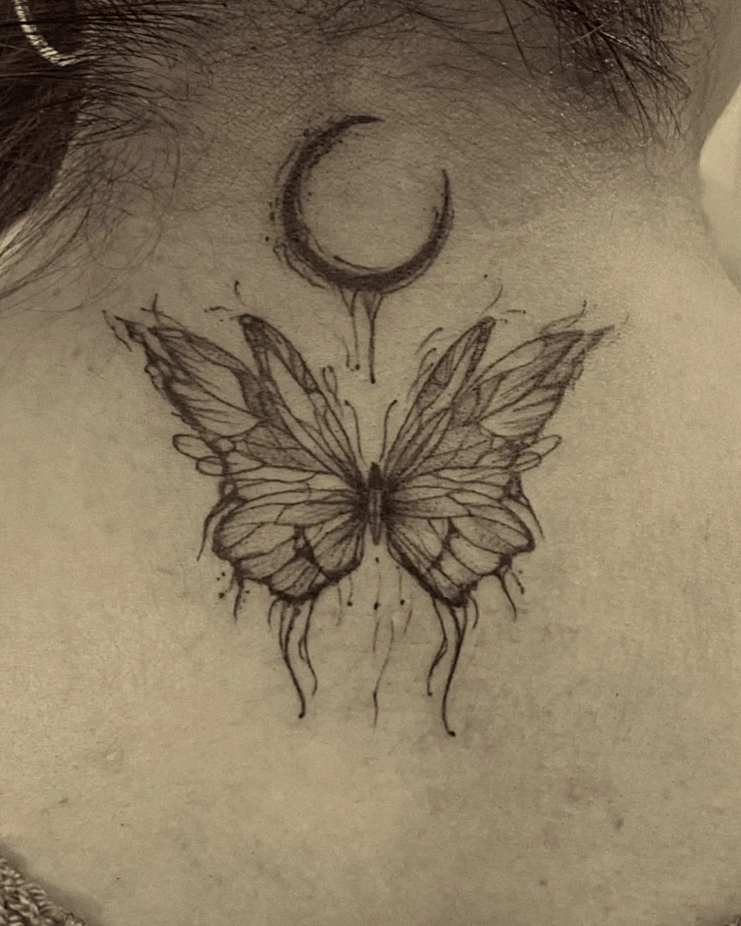 Mariposa y luna creciente en línea fina con sombra suave en la nuca
