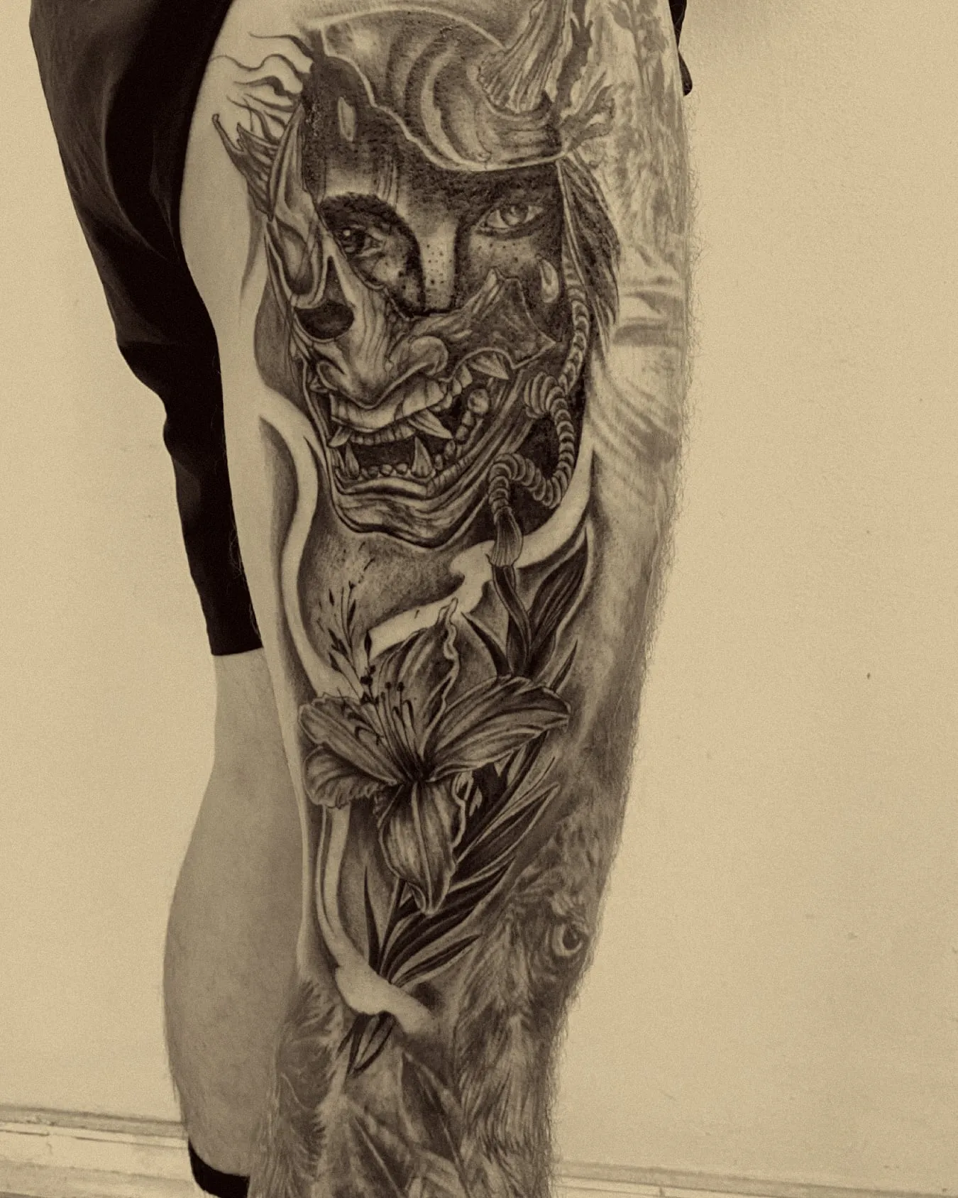 Máscara hannya con lirios en realismo negro y gris en la pierna